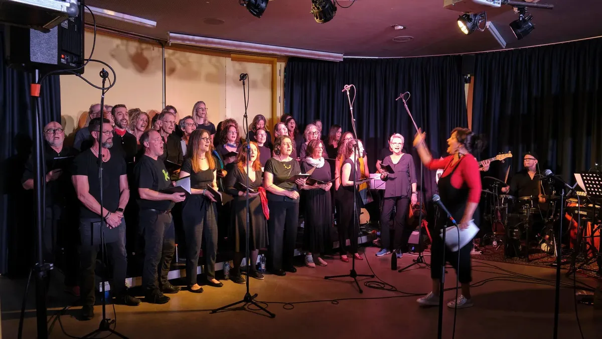 Man sieht eine Gruppe von Menschen singen.